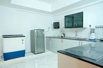a kitchen with a refrigerator and a counter top at 1 Bhk Luxury Flat in Samudhra Apartments -208 in Guruvāyūr