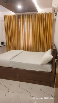 a bed in a room with a window with a curtain at 1 BHK Luxury Flat in Samudhra Apartments-105 in Guruvāyūr