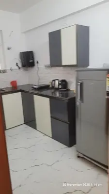 a kitchen with a counter and a refrigerator in it at 1 BHK Luxury Flat in Samudhra Apartments-105 in Guruvāyūr