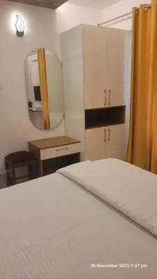 a bedroom with a white bed and a mirror at 1 BHK Luxury Flat in Samudhra Apartments-105 in Guruvāyūr
