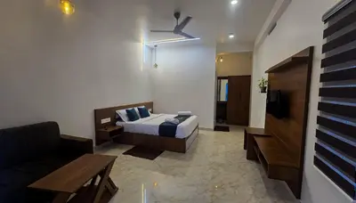a hotel room with a bed and a couch at White Oasis Residence Vythiri 3 star in Padinjarathara