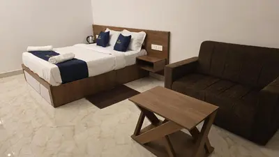 a hotel room with a bed and a chair at White Oasis Residence Vythiri 3 star in Padinjarathara