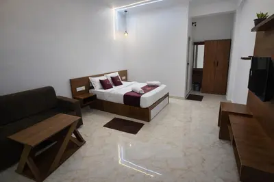 a hotel room with a bed and a couch at White Oasis Residence Vythiri 3 star in Padinjarathara