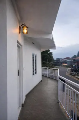 a balcony of a white building with a light on it at White Oasis Residence Vythiri 3 star in Padinjarathara