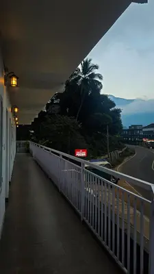 a bridge over a road with a palm tree in the distance at White Oasis Residence Vythiri 3 star in Padinjarathara