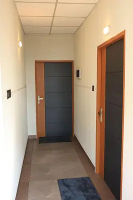 a hallway with two doors and a rug at Kghomestay in Pallipuram