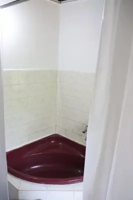 a red tub in a white tiled bathroom at Cinnamon Trails plantation bungalow in Kalpetta