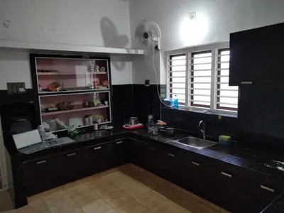 a kitchen with a sink and a counter top at Karmalhills Homestay in Tindummal