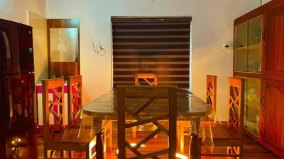 a dining room with a table and some chairs at Karmalhills Homestay in Tindummal