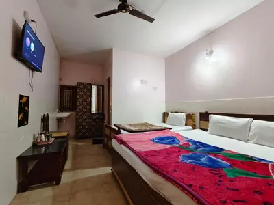 a bedroom with a bed and a flat screen tv at Pillars residency in Ooty