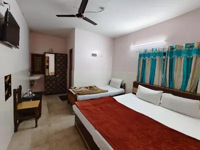 a hotel room with two beds and a ceiling fan at Pillars residency in Ooty