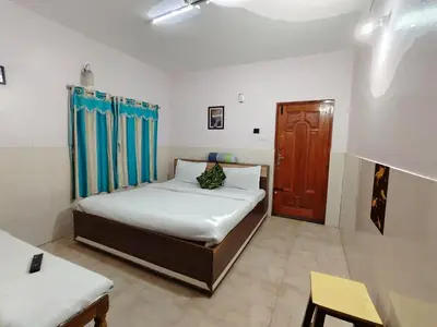 a bedroom with a bed and a wooden door at Pillars residency in Ooty