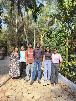 a group of people posing for a picture at Pearl Farmstay in Kushālnagar