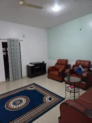 a living room with a couch and a table at Pearl Farmstay in Kushālnagar