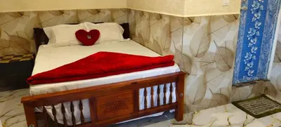 a small bed with a red heart pillow on it at Brigmonsiya in Vattavada