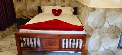 a bed with a red blanket on top of it at Brigmonsiya in Vattavada