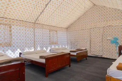a room with two beds and a wall of windows at Coorg Kavery Estate by Aarika Resorts in Napoklu