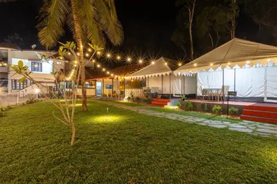a night view of a house with lights in a yard at Coorg Kavery Estate by Aarika Resorts in Napoklu