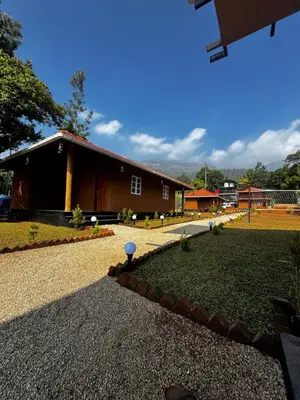 a house with a gravel driveway and a building at Marayoor Mud Castle in Marayoor