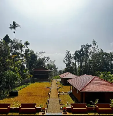 a garden with a pathway leading to a building at Marayoor Mud Castle in Marayoor