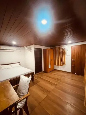 a room with a bed and a table in it at River bendHome in Viripara