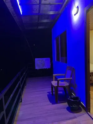 a blue room with a bench and a tv at River bendHome in Viripara