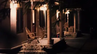 a group of chairs sitting on a porch at night at Uravu by LAKOTA in Chekadi