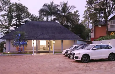 two cars parked in front of a house at Rippon Mount Resorts in Meppādi