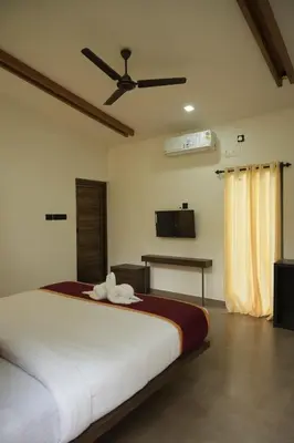 a bedroom with a bed with a ceiling fan at RockS VillA in Meppādi
