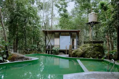 a house in the woods with a pool of water at RockS VillA in Meppādi