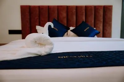 a bedroom with a bed with a swan on it at RockS VillA in Meppādi