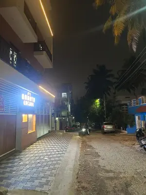 a building with a sign on the side of it at night at Royal Stay Mysuru Service Apartment in Mysore