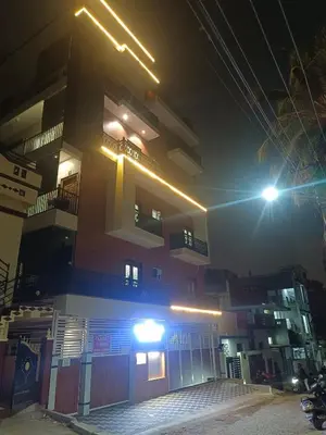 a building with lights on the side of it at night at Royal Stay Mysuru Service Apartment in Mysore