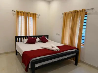a bedroom with a bed with two towels on it at ACK River Palms - Athirappilly in Athirappally