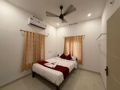 a bedroom with a bed and a ceiling fan at ACK River Palms - Athirappilly in Athirappally