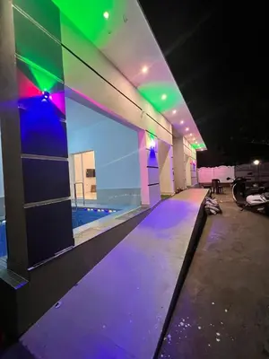 a room with purple and green lights on a building at ACK River Palms - Athirappilly in Athirappally
