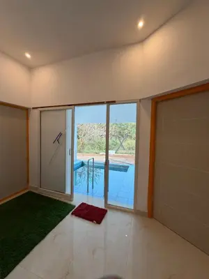 a room with a large glass door with a view of a pool at ACK River Palms - Athirappilly in Athirappally