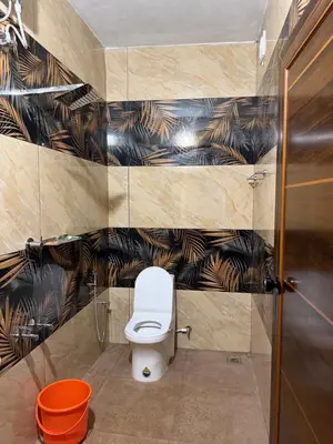 a bathroom with a toilet and black and brown wallpaper at ACK River Palms - Athirappilly in Athirappally