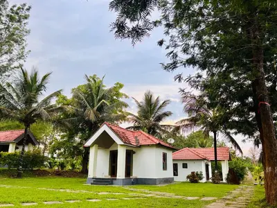a small white house with a red roof at Phalam Homestay in Kushālnagar