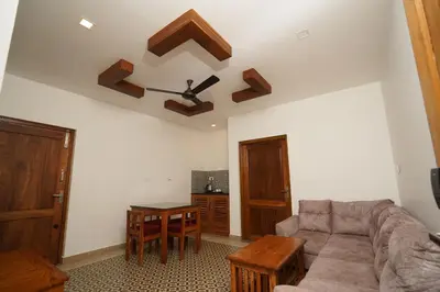 a living room with a couch and a table at Mango Village Resort in Kollengode