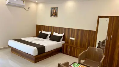 a bedroom with a bed and a chair in it at Estoria Hotel and Resort in Mysore