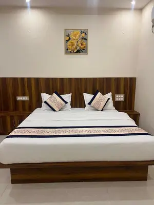 a bed with two pillows on it in a room at Estoria Hotel and Resort in Mysore