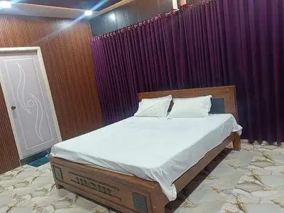 a bed in a room with purple curtains at Golden Valley Abode in Siddapur