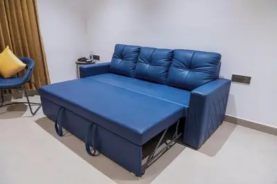 a blue couch in a room with a chair at Nes-Terns in Coimbatore