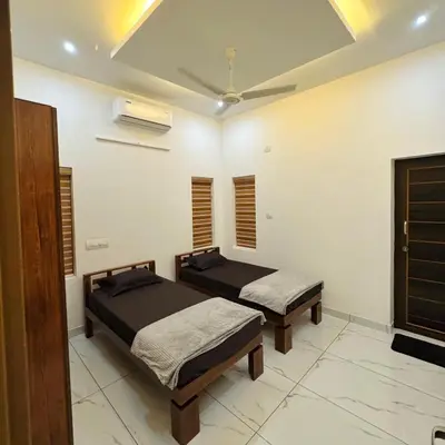 a bedroom with two beds and a ceiling at KM Villa in Kottakkal