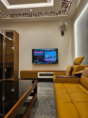 a living room with a couch and a tv at Kurunchi Malar Resorts in Hosūr