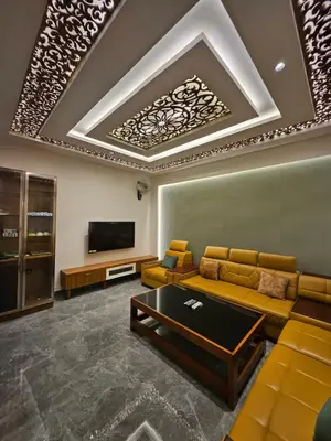 a living room with a couch and a tv at Kurunchi Malar Resorts in Hosūr