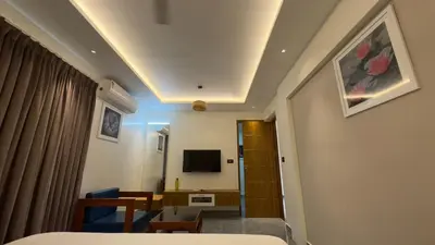 a bedroom with a bed and a desk and a tv at Kurunchi Malar Resorts in Hosūr