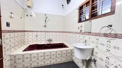 a bathroom with a red sink and a toilet at Royal Rivera Holiday Home in Kalpetta