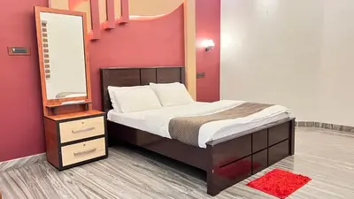 a bedroom with a bed with a mirror and a dresser at Royal Rivera Holiday Home in Kalpetta